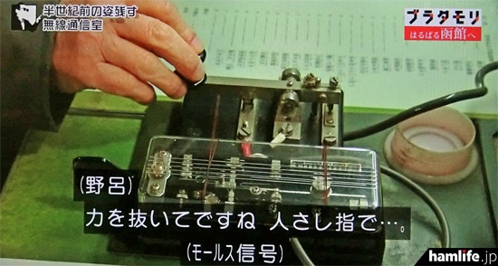 野呂氏の説明より早く、縦ぶれ電鍵で「CQ CQ JA6…」と打ち始めるタモリ（NHK「ブラタモリ」の映像より）