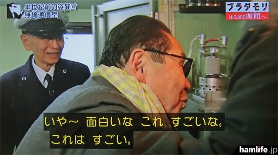 目を凝らして送信機の内部を見るタモリ（NHK「ブラタモリ」の映像より）