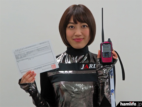 自身の無線局免許状とD-STARハンディ機を手にした松田百香