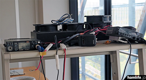 研究棟のデスク上にはアマチュア無線機も置かれていた。左は八重洲無線のFT-2312。メインダイヤルが取り外されている。右はJVCケンウッドのTM-833か？